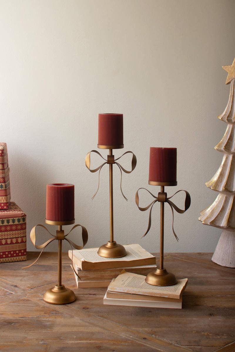 SET OF THREE ANTIQUE BRASS PILLAR CANDLE STANDS -BOW DETAIL: Gold / Metal / Large: 6.25" x 3.5" x 13.25"t;  
Medium: 6.25" x 3.5" x 11"t;  
Small: 6.25" x 3.5" x 8.75"t